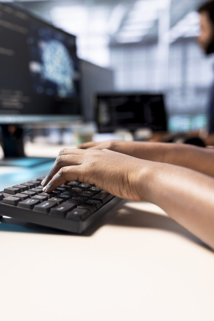 System administrator in server farm using AI systems, typing on keyboard